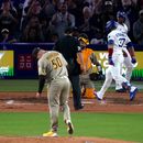 Teoscar Hernández (derecha), de los Dodgers de Los Ángeles, anota tras conectar un grand slam mientras Max Muncy (izquierda) lo espera y el lanzador de los Padres de San Diego, Adrián Morejón, permanece en el montículo durante la séptima entrada de un partido de béisbol, el viernes 3 de julio de 2026, en Los Ángeles. (Foto AP/Mark J. Terrill)