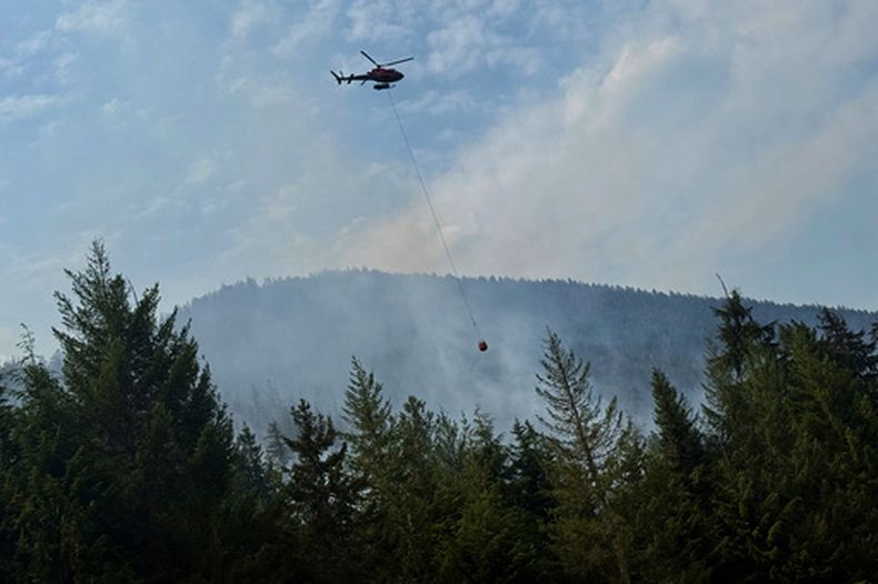 Aeronaves cisterna dejan caer agua sobre un incendio forestal a lo largo de la Autopista 3, el miércoles 12 de agosto de 2026, en Manning Park, Columbia Británica, Canadá. (AP Foto/Haven Daley)
