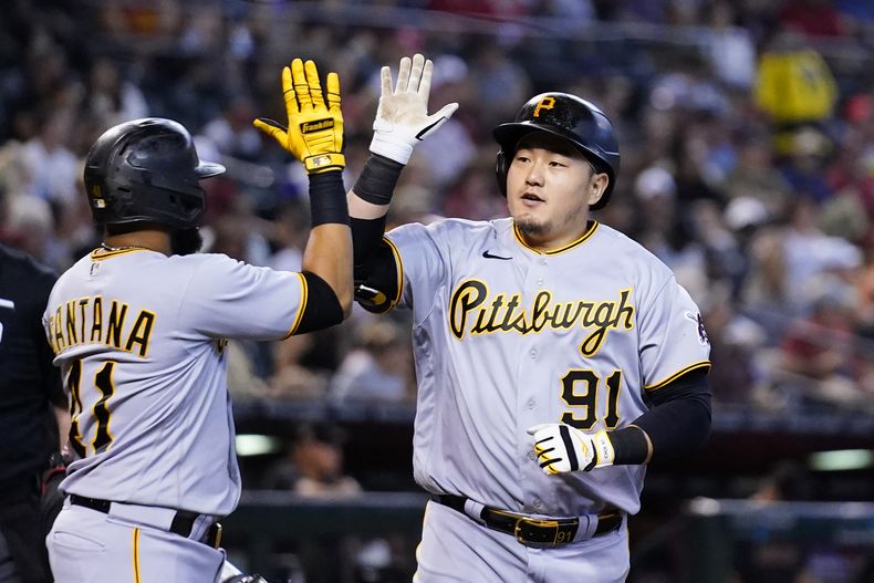 Ji Man Choi (91), de Corea del Sur, celebra su cuadrangular de dos carreras en contra de los Diamondbacks de Arizona, con Carlos Santana, izquierda, durante la segunda entrada del juego de béisbol, el domingo 9 de julio de 2023, en Phoenix. (AP Foto/Ross D. Franklin)