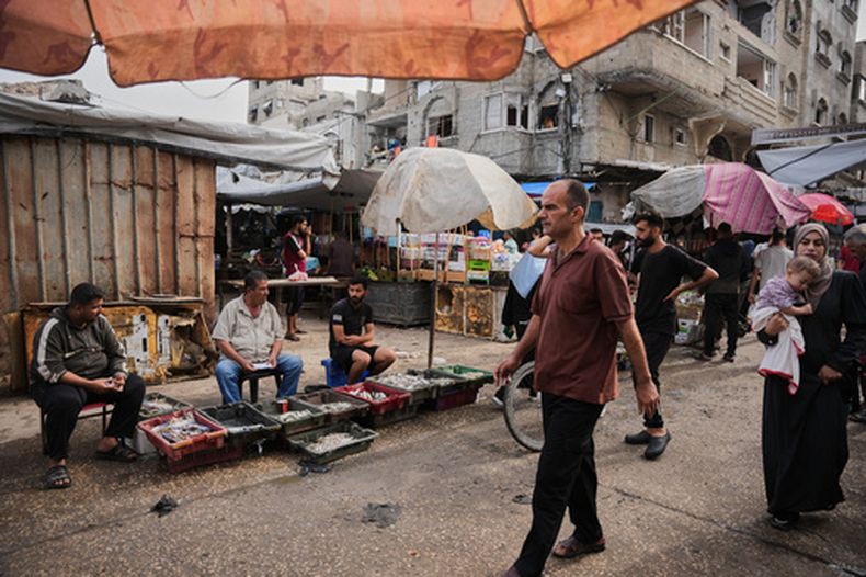 Palestinos caminan por un mercado en el campamento de refugiado Al-Shati en Ciudad de Gaza, el miércoles 14 de octubre de 2026. (AP Foto/Abdel Kareem Hana)