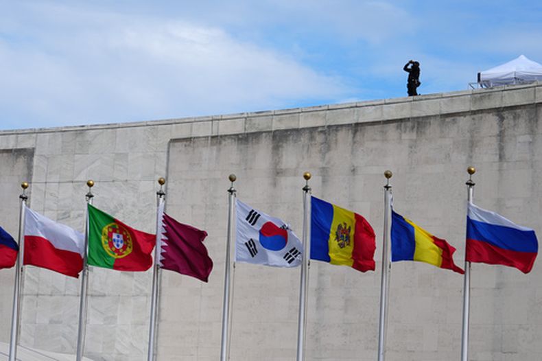 Banderas ondean en la sede de Naciones Unidas el 22 de septiembre de 2026 en la sede de Naciones Unidas mientras un efectivo de las fuerzas de seguridad vigila la zona. (AP Foto/Julia Demaree Nikhinson)