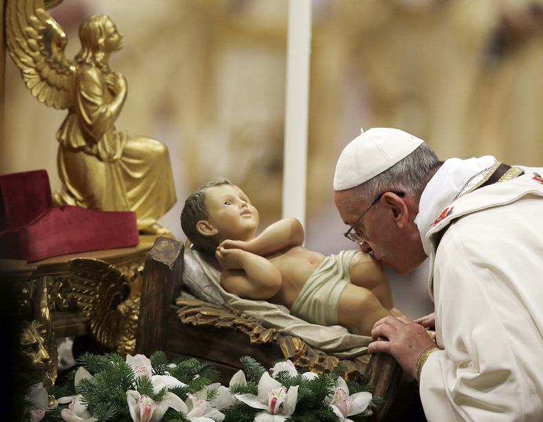 El papa Francisco besa la estatua del ni&ntilde;o Jes&uacute;s al celebrar la misa de la Nochebuena en la Bas&iacute;lica de San Pedro, en el Vaticano, el martes 24 de diciembre de 2013. (Foto AP/Gregorio Borgia)