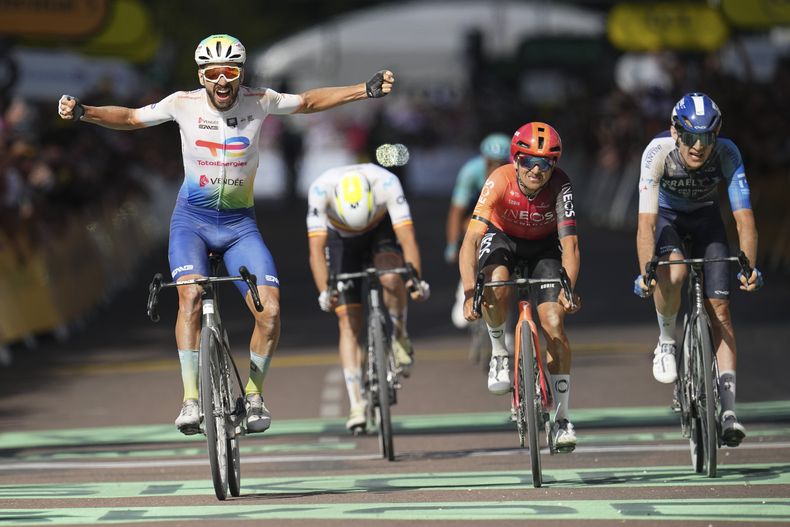 El francés Anthony Turgis celebra al cruzar la línea de meta en el primer lugar frente al británico Thomas Pidcock y el canadiense Derek Gee en la novena etapa del Tour de Francia el domingo 7 de julio del 2024. (AP Foto/Daniel Cole)