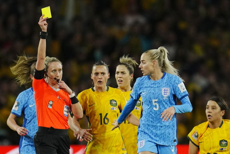 En foto del miércoles 16 de agosto del 2023, la árbitra Tori Penso le muestra una tarjeta amarilla a Alex Greenwood de Inglaterra durante la semifinal de la Copa Mundial femenina ante Australia. El viernes 18 de agosto del 2023, FIFA elige a Penso para pitar la final del domingo. (AP Foto/Abbie Parr)
