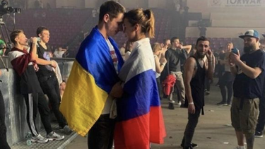 pareja abrazada con las banderas de ucrania y rusia: el amor puede vencer cualquier cosa