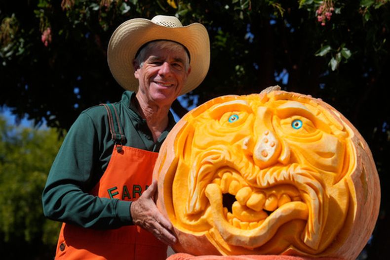 Mike Valladao junto con una calabaza tallada en Half Moon Bay, California, el 12 de octubre del 2026. (AP foto/Jeff Chiu)