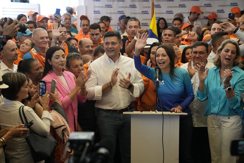 La aspirante presidencial de la oposición María Corina Machado y el líder opositor Freddy Superlano, ambos al centro, levantan los brazos para los fotógrafos durante un evento de campaña en Caracas, Venezuela, el viernes 13 de octubre de 2023. Superlano anunció su retiro de las primarias y el apoyo de su partido, Voluntad Popular, a Machado antes de las primarias de la oposición para elegir un candidato que se enfrente al presidente Nicolás Maduro en las elecciones generales de 2024. (Foto AP/Ariana Cubillos)