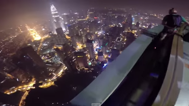 americateve | Los paracaidistas John Van Horne, Matt Frohlich y Andy Lewis se lanzaron desde la cima de la Torre de Kuala Lumpur, en Malasia, y aterrizaron en una fiesta en el techo de un edificio cercano