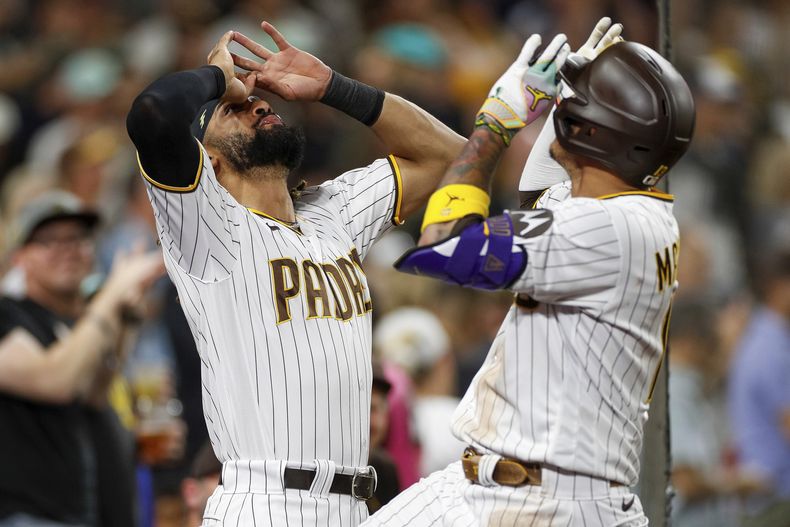 Manny Machado de los Padres de San Diego celebra con el dominicano Fernando Tatis Jr. tras pegar un jonrón solitario en la sexta entrada del juego ante los Marlins de Miami el lunes 21 de agosto del 2023. (AP Foto/Brandon Sloter)