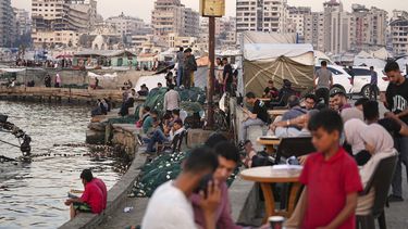 Palestinos en la costa, cerca de un campamento de carpas en el puerto de Ciudad de Gaza, el viernes 13 de junio de 2025. (AP Foto/Jehad Alshrafi)