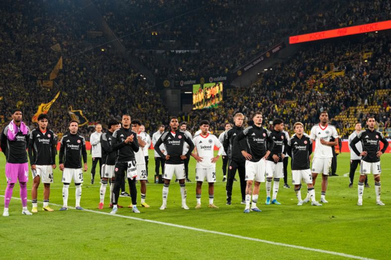 Jugadores del Frankfurt se paran frente a sus fanáticos después de la derrota en partido de fútbol de la Bundesliga frente a Borussia Dortmund, el viernes 8 de mayo de 2026, en Dortmund, Alemania. (AP Foto/Martin Meissner)