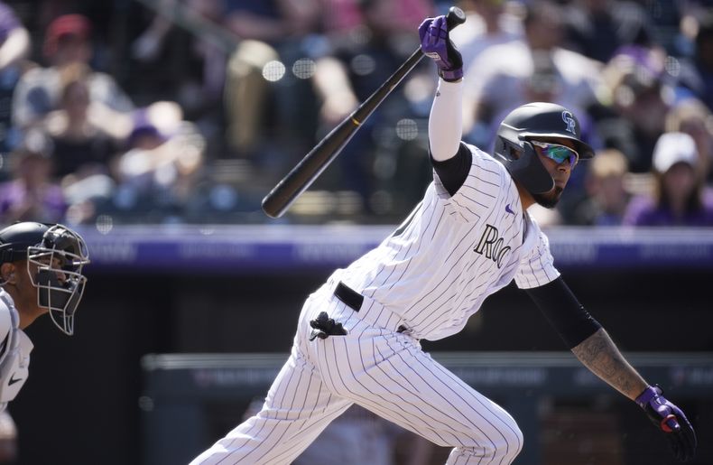 Harold Castro, de los Rockies de Colorado, pega un sencillo ante los Diamondbacks de Arizona, el domingo 30 de abril de 2023, en Denver. (AP Foto/David Zalubowski)