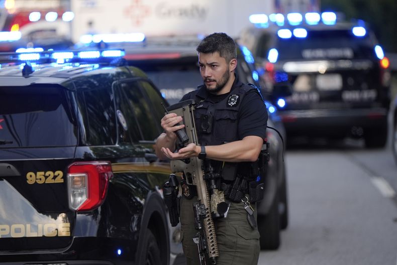 Un policía armado se prepara cerca de la escena de un tiroteo en la Universidad de Emory en Atlanta, el viernes 8 de agosto de 2025. (AP Foto/Mike Stewart)