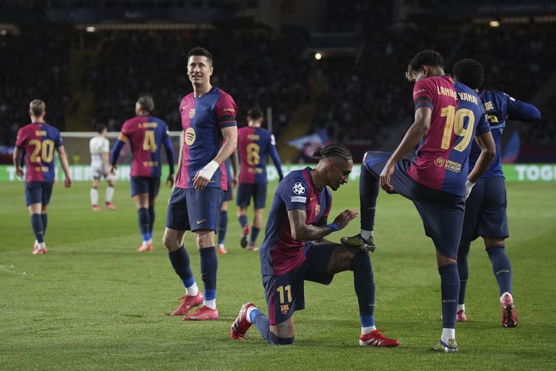 Lamine Yamal celebra con su compañero Raphinha tras anotar el segundo gol del Barcelona ante Benfica en la vuelta de los octavos de final de la Liga de Campeones, el martes 11 de marzo de 2025, en Barcelona. (AP Foto/Emilio Morenatti)