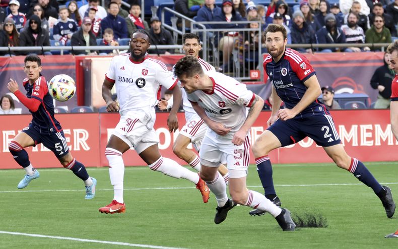 El defensa del Toronto FC, Kevin Long (5), hace contacto con el balón por delante de Dave Romney (2), del New England Revolutión, en el segundo tiempo del partido de fútbol de la MLS, el domingo 3 de marzo de 2024, en Foxborough, Massachusetts. (AP Foto/Mark Stockwell)