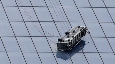 americateve | Un andamio parcialmente desprendido cuelga de la fachada del World Trade Center en Nueva York, el mi&eacute;rcoles, 12 de noviembre del 2014. Dos limpiaventanas que estaban colgados rpecariamente en el andamio junto al 69no piso del edificiotuvieron que s