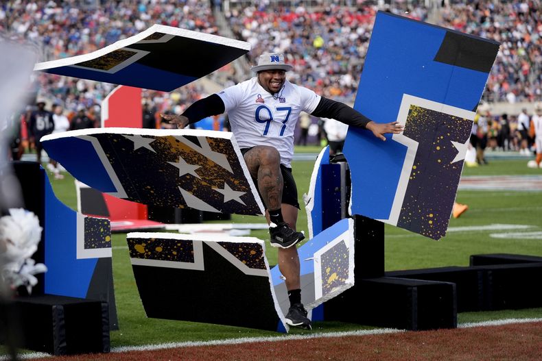 ARCHIVO - Dexter Lawrence, de los Giants de Nueva York, rompe una barrera durante la competición de habilidades en el marco del Pro Bowl, el 4 de febrero de 2024, en Orlando (AP Foto/John Raoux, archivo)