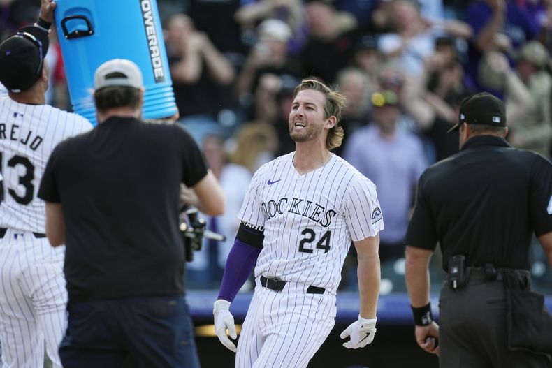 Ryan McMahon, de los Rockies de Colorado, llega al plato después de batear un grand slam frente al lanzador de los Rays de Tampa Bay, Jason Adam, durante la novena entrada del juego de béisbol, el viernes 5 de abril, en Denver. (AP Foto/David Zalubowski)