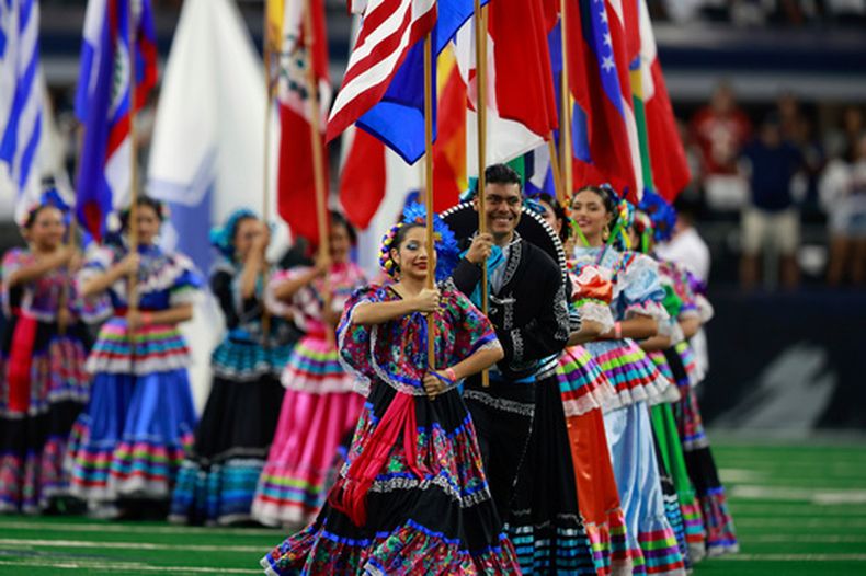 ARCHIVO - Banderas nacionales de países latinoamericanos se ven en el campo durante una celebración el Mes de la Herencia Hispana antes de un juego de la NFL entre los Ravens de Baltimore y los Cowboys de Dallas en Arlington, Texas, el 22 de septiembre de 2024. (AP Foto/Gareth Patterson, Archivo)