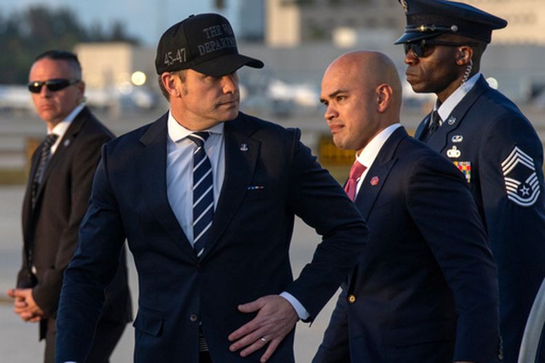 El secretario de Defensa, Pete Hegseth (izquierda, con gorra), y Walt Nauta, asesor personal del presidente Donald Trump, descienden del Air Force One el sábado 7 de marzo de 2026, en el Aeropuerto Internacional de Miami. (AP Foto/Mark Schiefelbein)
