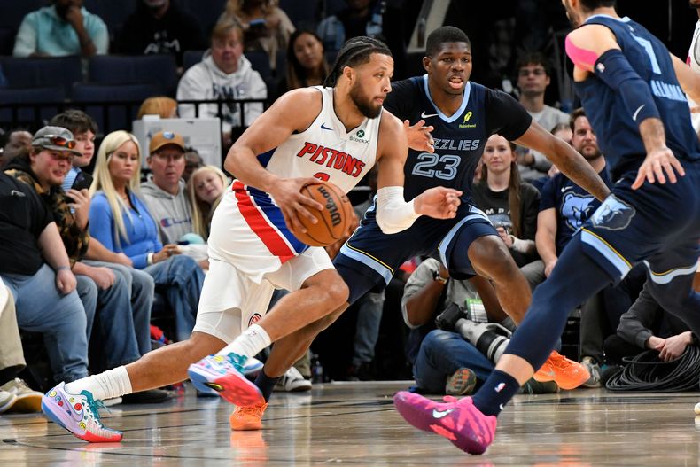 El base de los Pistons de Detroit Cade Cunningham avanza con el balón frente al alero de los Grizzlies de Memphis Cedric Coward en el encuentro del lunes 3 de noviembre del 2025. (AP Foto/Brandon Dill)