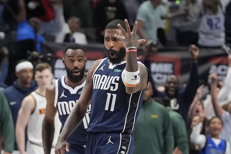 El armador de los Mavericks de Dallas Kyrie Irving (11) reacciona mientras su compañero Tim Hardaway Jr. se acerca luego de anotar el triple ganador en la segunda mitad del juego de baloncesto de la NBA, ante los Nuggets de Denver, en Dallas, el domingo 17 de marzo de 2024. (AP Foto/LM Otero)