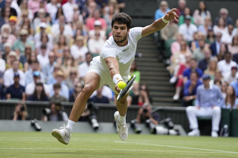 Carlos Alcaraz devuelve ante Novak Djokovic en la final de Wimbledon, el domingo 16 de julio de 2023, en Londres. (AP Foto/Kirsty Wigglesworth)