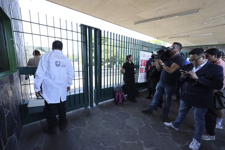 Un trabajador del servicio forense espera a entrar al Parque Bicentenario en la Ciudad de México el domingo 6 de abril de 2025, después de que el festival AXE Ceremonia fuera suspendido por el colapso de una estructura que mató a dos fotógrafos el día antes. (Foto AP/Ginnette Riquelme)