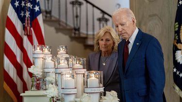 El presidente Joe Biden, acompañado por la primera dama Jill Biden, observa flores y velas con los nombres de las víctimas de la masacre en una escuela primaria de Uvalde, Texas, en el primer aniversario del incidente, el miércoles 24 de mayo de 2023, en la Casa Blanca, Washington. (AP Foto/Andrew Harnik)