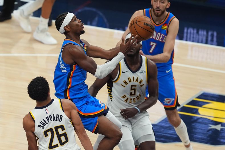 Shai Gilgeous-Alexander, del Thunder de Oklahoma City, salta hacia la cesta frente a Bon Sheppard, de los Pacers de Indiana, en la segunda prórroga del duelo del jueves 23 de octubre de 2025 (AP Foto/Darron Cummings)