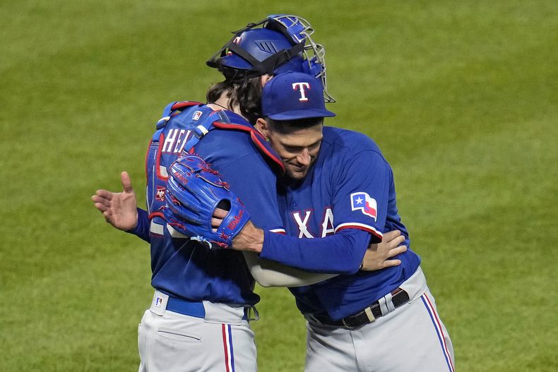 Nathan Eovaldi, abridor de los Rangers de Texas, festeja con el cátcher Jonah Heim la victoria sobre los Piratas de Pittsburgh, el martes 23 de mayo de 2023 (AP Foto/Gene J. Puskar)