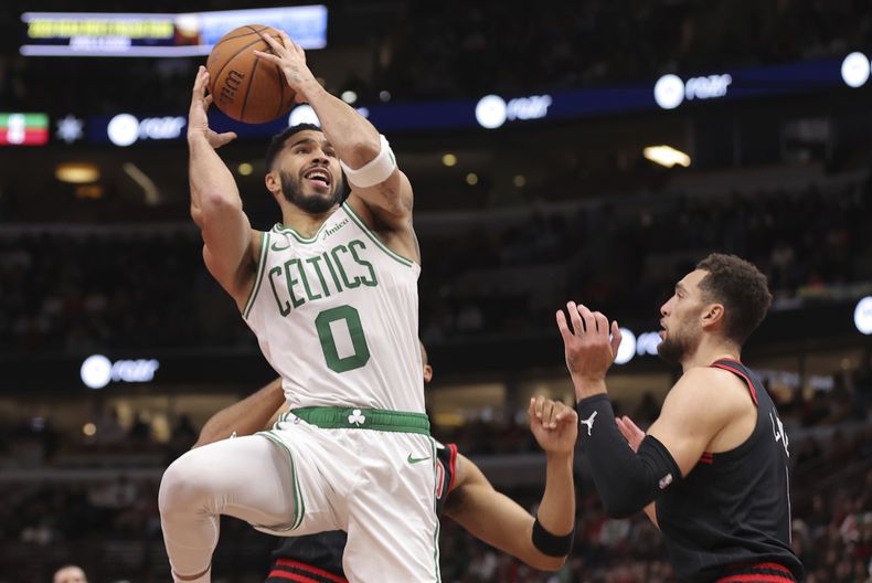 Jayson Tatum, alero de los Celtics de Boston, salta para disparar frente a Zach LaVine, de los Bulls de Chicago, en el encuentro del viernes 29 de noviembre de 2024 (AP Foto/Melissa Tamez)