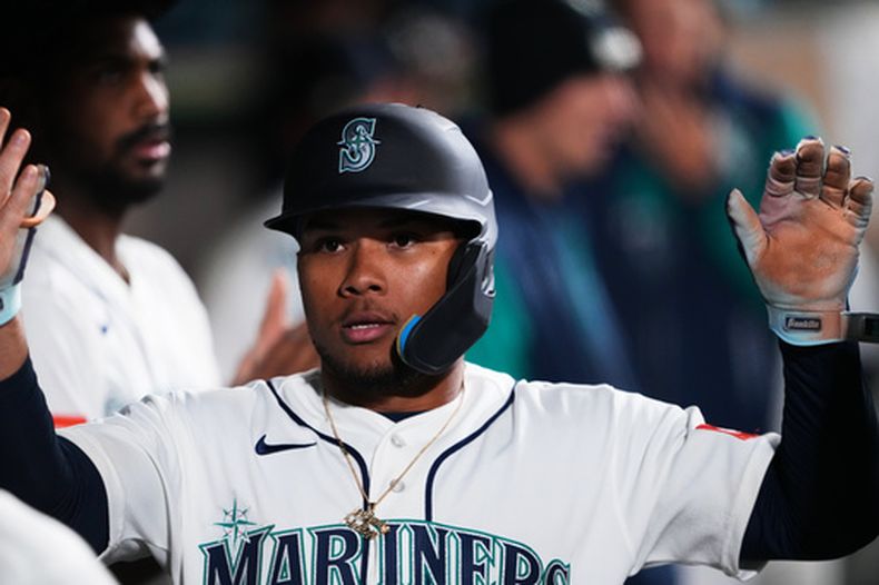 Michael Arroyo de los Marineros de Seattle es felicitado en el dugout tras anotar con el sencillo de dos carreras de Taylor Ward en la séptima entrada ante los Angelinos de Los Ángeles el sábado 26 de septiembre del 2026. (AP Foto/Lindsey Wasson)