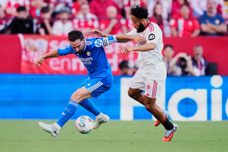 Dani Carvajal (izquierda) del Real Madrid pugna el balón con Chidera Ejuke de Sevilla en un partido de la Liga de España, el domingo 17 de mayo de 2026, en Sevilla. (AP Foto/José Bretón)