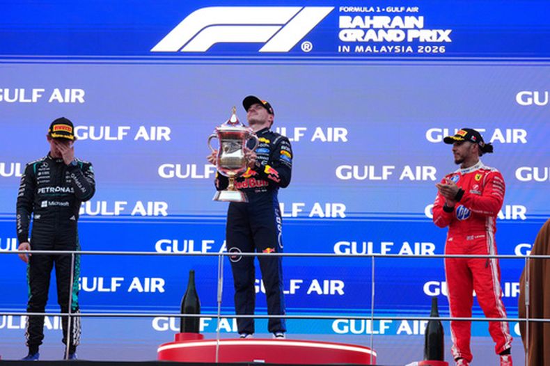 El neerlandés Verstappen, de Red Bull, celebra con el trofeo tras ganar el Gran Premio de Baréin en Malasia, flanqueado por el italiano Kimi Antonelli, de Mercedes, que fue segundo, y el británico Lewis Hamilton, de Ferrari, que fue tercero, el domingo 4 de octubre del 2026. (AP Foto/Vincent Thian)