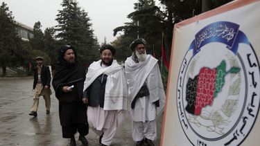 americateve | Delegados afganos pasan junto a un cartel de Loya Jirga, una asamblea conformada por miles de personalidades prominentes de todo el pa&iacute;s, en el tercer d&iacute;a de reuniones en Kabul, Afganist&aacute;n, el s&aacute;bado 23 de noviembre de 2013. El