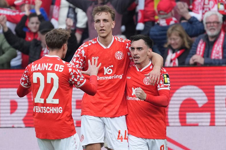 Paul Nebel del Mainz celebra con sus compañeros Nelson Weiper y Nikolas Veratschnig en el encuentro de la Bundesliga ante el Eintracht Frankfurt el domingo 22 de marzo del 2026. (Marc Schueler/dpa via AP)
