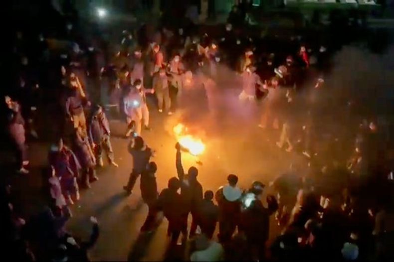 En esta imagen tomada de un video difundido en redes sociales, manifestantes bailan y cantan en torno a una hoguera mientras salen a la calle pese a una campaña de represión redoblada, y con la república islámica aislada del resto del mundo, en Teherán, el viernes 9 de enero de 2026. (UGC via AP)