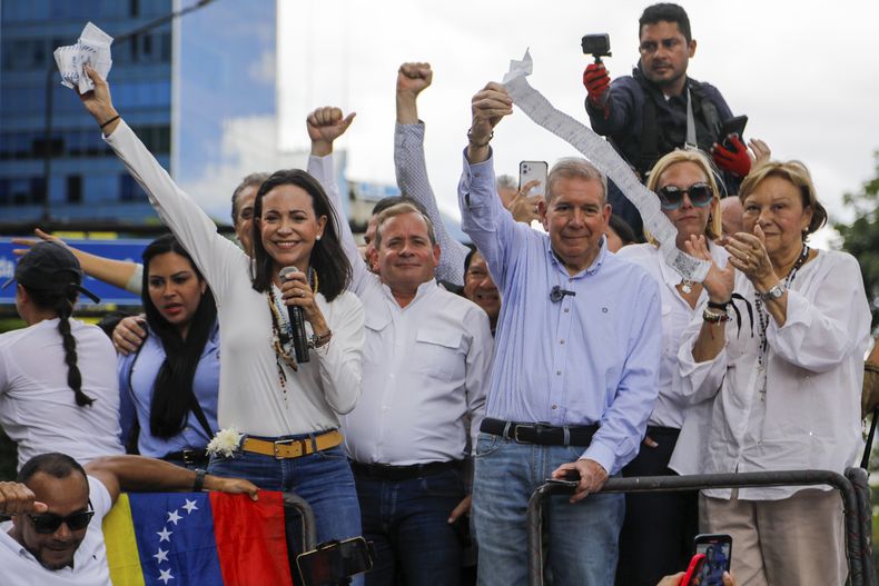 La líder opositora María Corina Machado, izquierda, y el candidato opositor Edmundo González sostienen actas de recuento de votos desde la parte superior de un camión durante una protesta contra los resultados oficiales de las elecciones presidenciales --los cuales declaran ganador al presidente Nicolás Maduro--, en Caracas, Venezuela, el martes 30 de julio de 2024, dos días después de las elecciones. (AP Foto/Cristian Hernandez)
