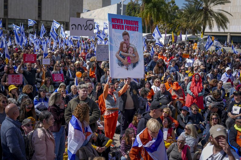 La gente ve una transmisión en vivo del funeral de los rehenes Shiri Bibas y sus dos hijos, Ariel y Kfir, en una plaza conocida como la Plaza de los Rehenes en Tel Aviv, Israel, el miércoles 26 de febrero de 2025. La madre y sus dos hijos fueron secuestrados por Hamás el 7 de octubre de 2023, y sus restos fueron devueltos de Gaza a Israel la semana pasada como parte de un acuerdo de alto el fuego con Hamás. (AP Foto/Ariel Schalit)