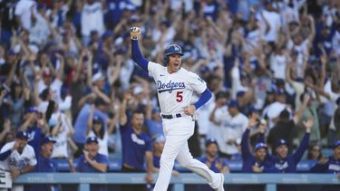 Freddie Freeman (5), de los Dodgers de Los Ángeles, festeja y anota después de que su compañero Will Smith (16) conectara un jonrón en la octava entrada del partido contra los Astros de Houston, en Los Ángeles, el domingo 25 de junio de 2023. Freeman logró en ese inning su hit 2.000. (AP Foto/Ashley Landis)