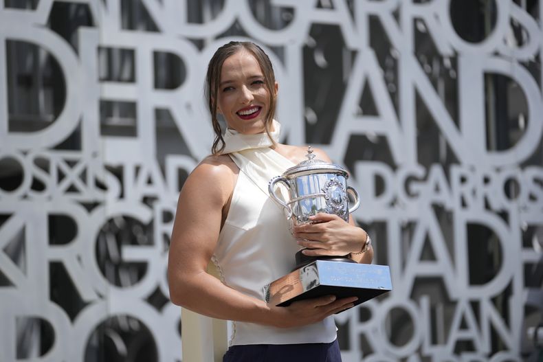 La polaca Iga Swiatek sostiene el trofeo de campeona del Abierto de Francia mientras posa para la prensa al día siguiente de que ganó el domingo 9 de junio del 2024. (AP Foto/Thibault Camus)