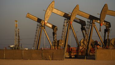 Varios caballetes operan cerca del lugar de donde se está perforando un nuevo pozo de gas y petróleo el viernes 8 de abril de 2022 en Midland, Texas. Exxon Mobil comprará Pioneer Natural Resources en un acuerdo enteramente en acciones valoradas en 59.500 millones de dólares, su adquisición más grande desde que compró Mobil hace dos décadas y que crea una enorme compañía de fracturación hidráulica en el oeste de Texas. (Eli Hartman/Odessa American via AP, Archivo)