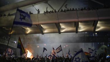 Una hoguera arde mientras israelíes ocupan la autopista Ayalon para protestar contra la propuesta de reforma del sistema judicial del gobierno del primer ministro, Benjamin Netanyahu, en Tel Aviv, el 20 de julio de 2023. (AP Foto/Ariel Schalit)