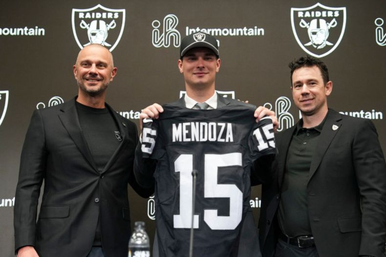 De izquierda a derecha: John Spytek, gerente general de los Raiders; Fernando Mendoza, la primera selección global del Draft de la NFL; y Klint Kubiak, entrenador en jefe, posan para la foto durante la conferencia de prensa de presentación de Mendoza, el viernes 24 de abril de 2026, en Henderson, Nevada. (AP Foto/Candice Ward)