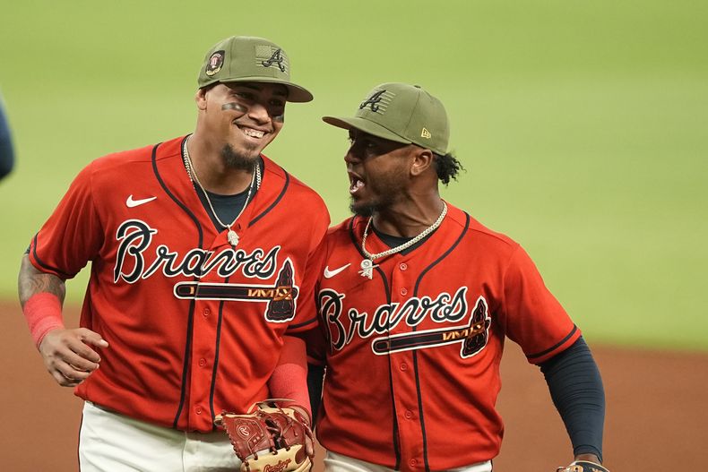 El venezolano Orlando Arcia, de los Bravos de Atlanta, festeja con su compañero Ozzie Albies tras una doble matanza ante los Marineros de Seattle, el viernes 19 de mayo de 2023 (AP Foto/Brynn Anderson)