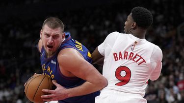Nikola Jokic, izquierda, de los Nuggets de Denver, intenta superar a RJ Barrett (9), de los Raptors de Toronto, durante la segunda mitad del juego de baloncesto de la NBA, el lunes 28 de octubre de 2024, en Toronto. (Nathan Denette/The Canadian Press vía AP)