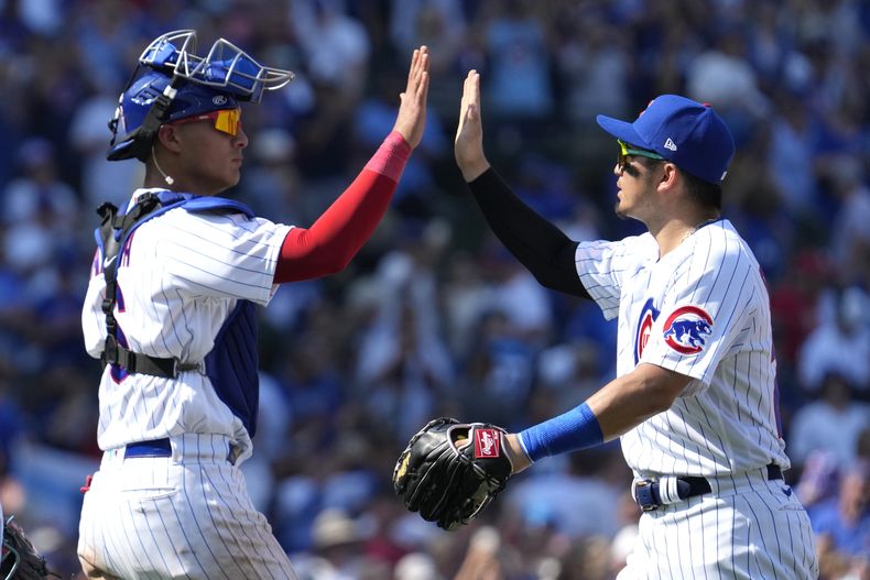 El cátcher panameño de los Cachorros de Chicago Miguel Amaya celebra con el jardinero derecho Seiya Suzuki la victoria ante los Reales de Kansas City el domingo 20 de agosto del 2023. (AP Foto/Nam Y. Huh)