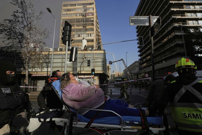 Una mujer en una camilla tras ser evacuada de un edificio con un incendio en Santiago, Chile, el jueves 10 de julio de 2025. (AP Foto/Esteban Félix)