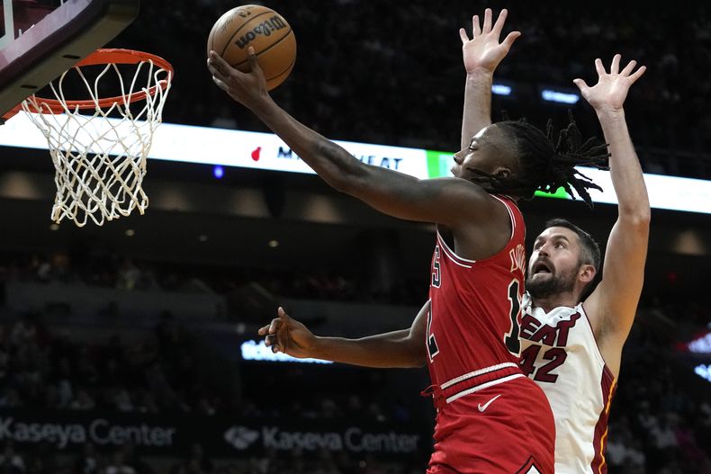 Ayo Donsumu, de los Bulls de Chicago, salta para encestar frente a Kevin Love, del Heat de Miami, en el partido del jueves 14 de diciembre de 2023 (AP Foto/Lynne Sladky)